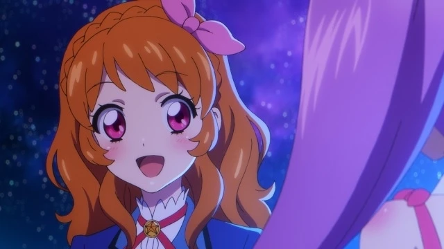 Escena del crossover Aikatsu! × PriPara The Movie mostrando a Akari Ozora con expresión alegre bajo un cielo estrellado, reflejando el espíritu optimista y soñador de los ídolos durante la colaboración.