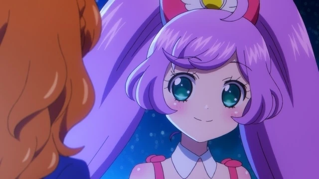 Primer plano de Laala Manaka sonriendo con ternura bajo un cielo estrellado en Aikatsu! × PriPara The Movie, simbolizando la conexión emocional y el lazo entre mundos idol.