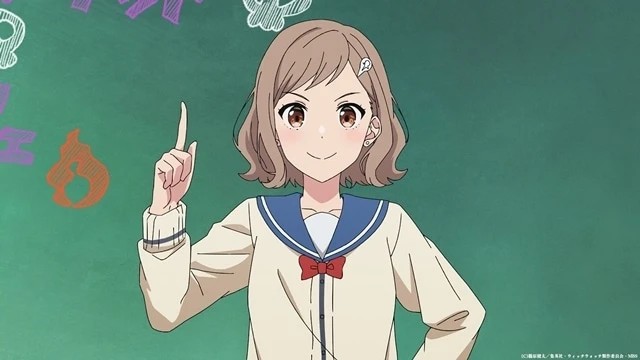 Estudiante de 『Witchwatch』 levanta el dedo en señal de explicación frente a una pizarra con símbolos mágicos, en una escena del episodio 25.