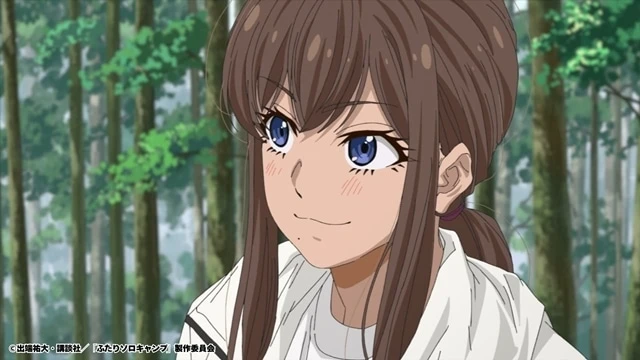 Primer plano de Yui, sonriendo con confianza entre los árboles durante su encuentro con Gen en el episodio 17 del anime Futari Solo Camp.